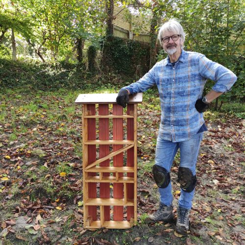 The bug hotel is open for guests Friendly fellow leaning on a bug hotel